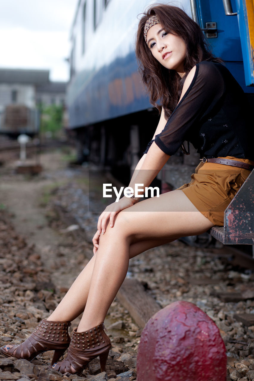 Fashionable woman sitting on train door