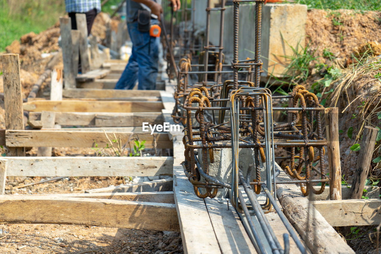 Low section of men working at construction site with structure of reinforcement steel