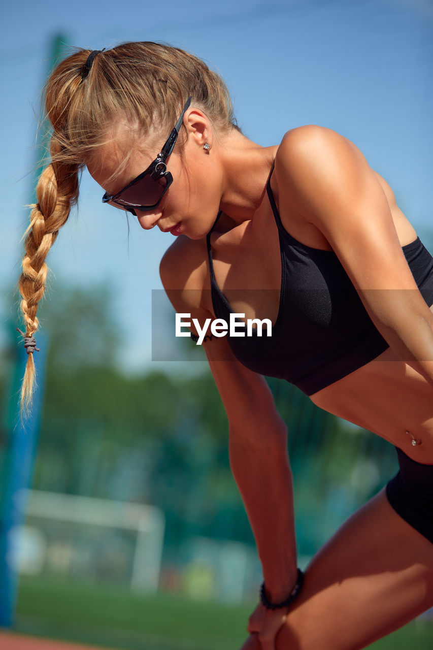 low angle view of young woman exercising at park