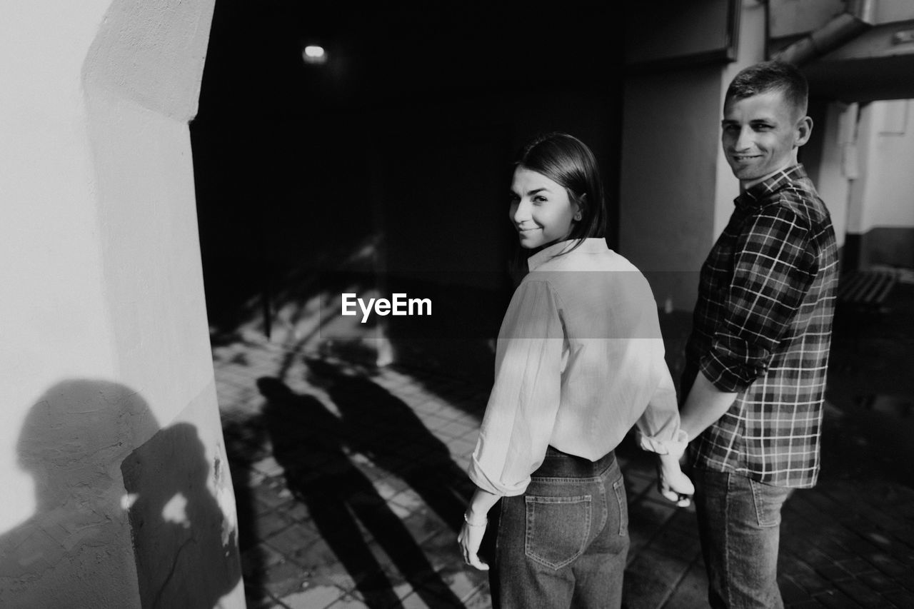 PORTRAIT OF TWO WOMEN STANDING IN FRONT OF PEOPLE