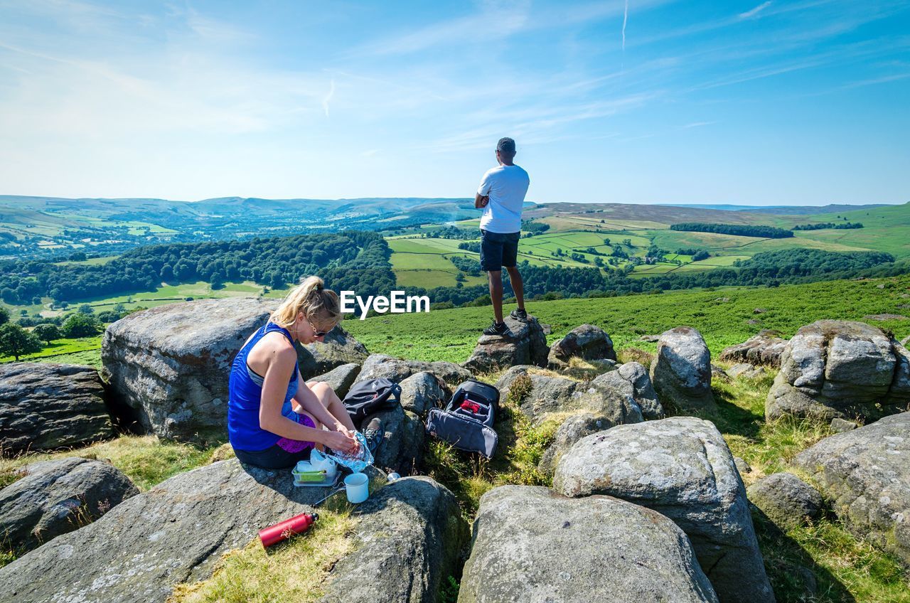 People sitting at landscape against sky