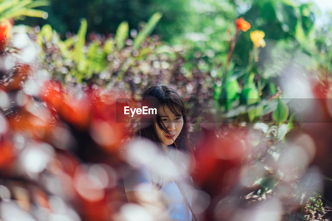 Woman looking away seen through plants