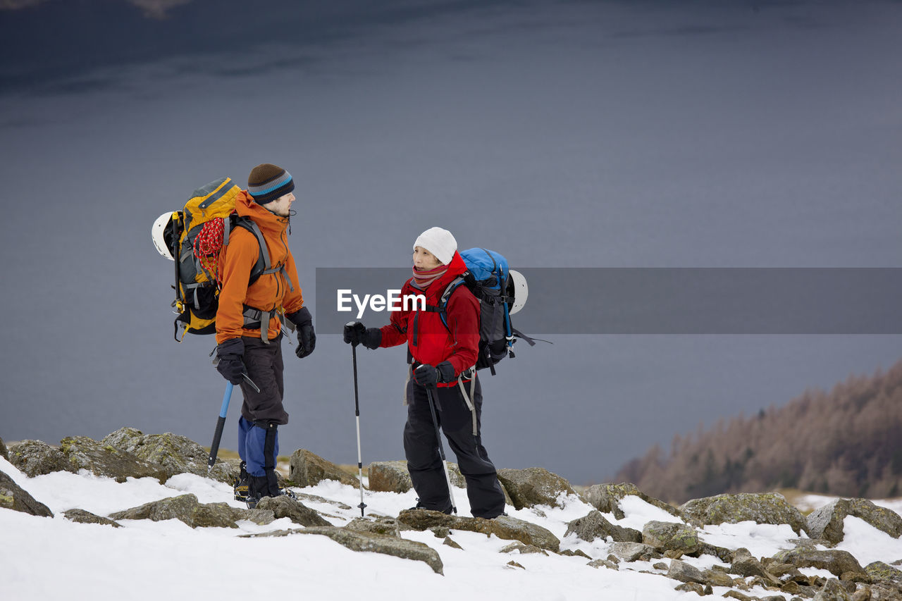 Couple hiking up helvellyn mountain in the lake district