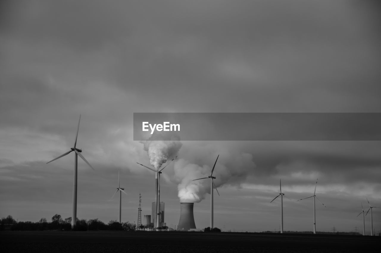 Windmills on landscape against sky