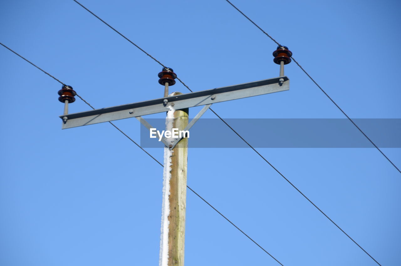 LOW ANGLE VIEW OF POWER LINES AGAINST CLEAR SKY