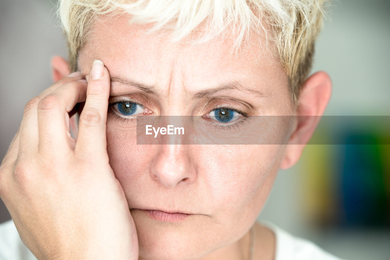 Close-up of blond woman with headache