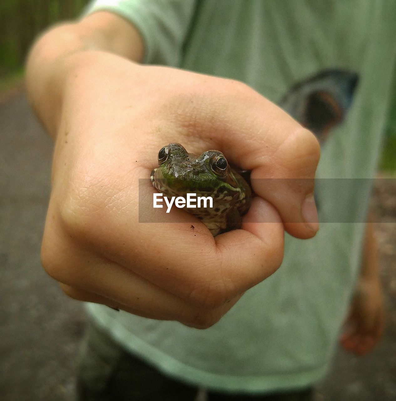 CLOSE-UP OF HAND HOLDING SNAKE