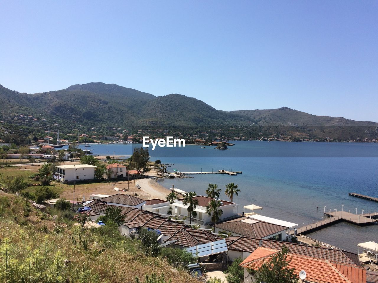 High angle view of buildings by sea against clear sky