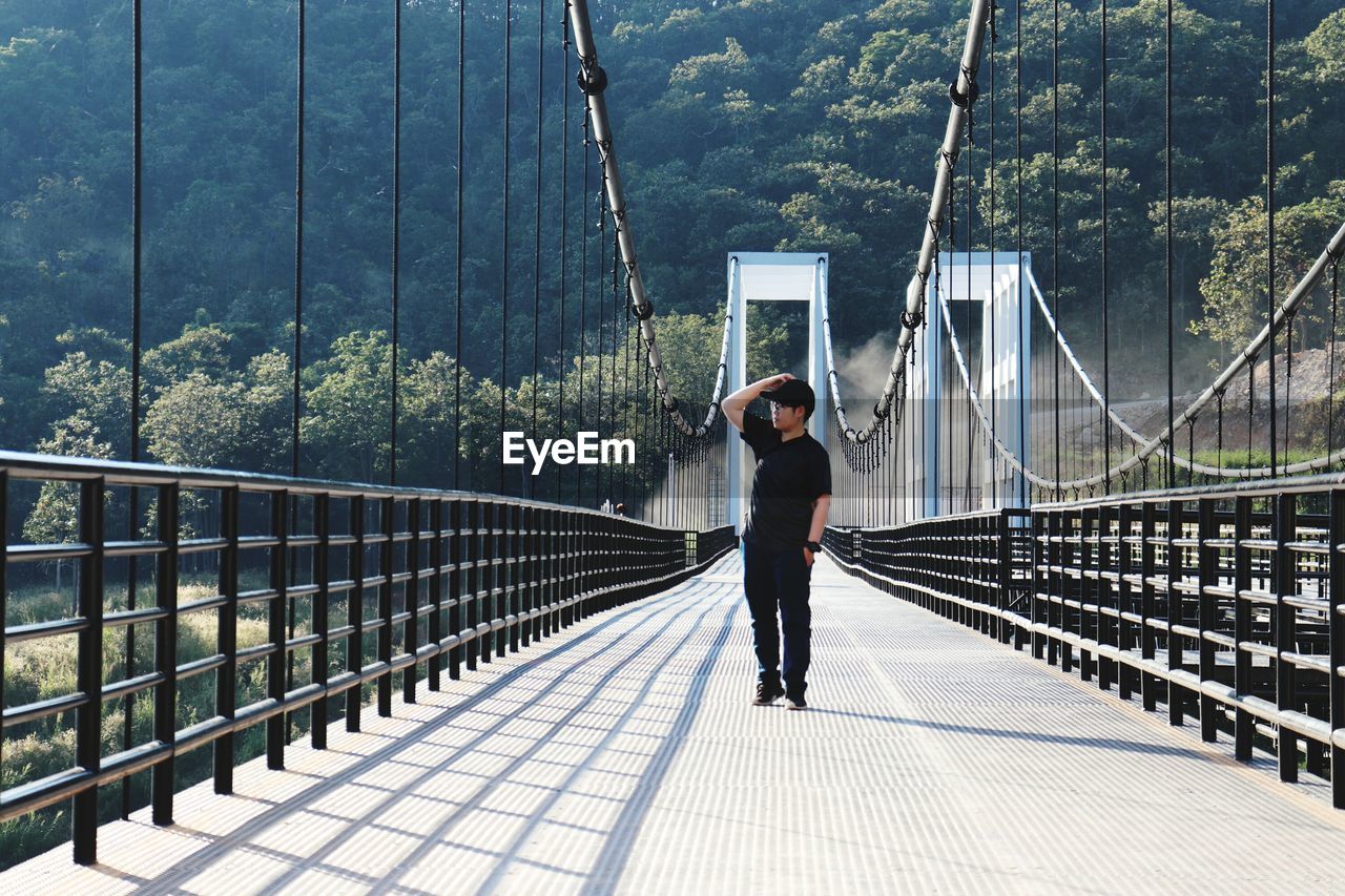 Full length of man standing on footbridge