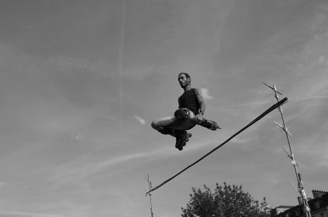 LOW ANGLE VIEW OF GIRL JUMPING IN SKY