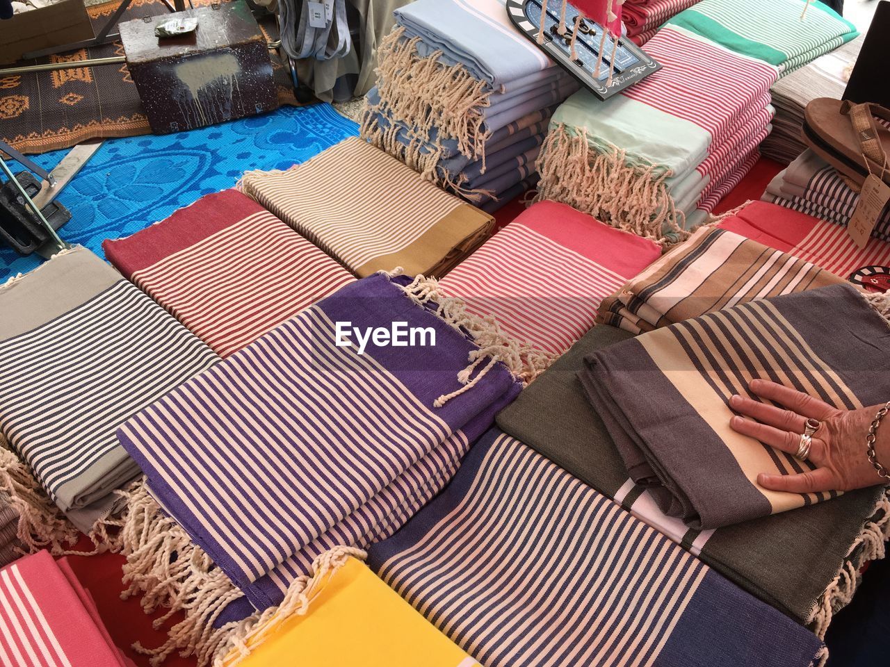 Cropped hand of woman touching textile for sale at market stall