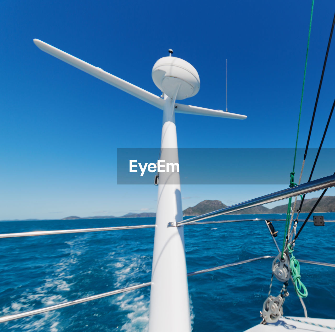 WHITE SAILBOAT ON SEA AGAINST CLEAR BLUE SKY