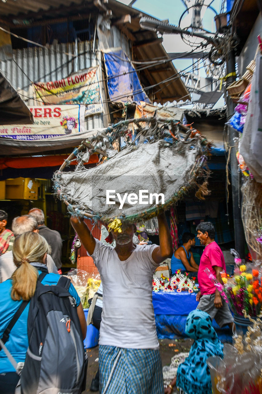 REAR VIEW OF PEOPLE AT MARKET STALL