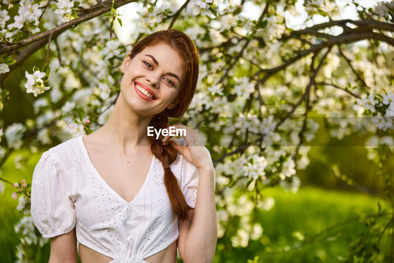 young woman looking away against plants