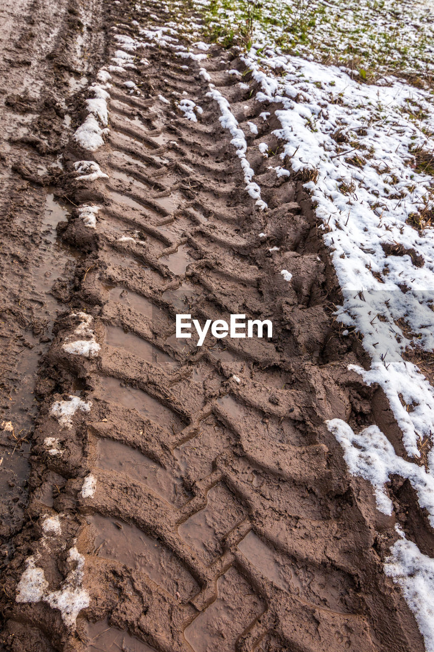 HIGH ANGLE VIEW OF TIRE TRACKS ON ROCK