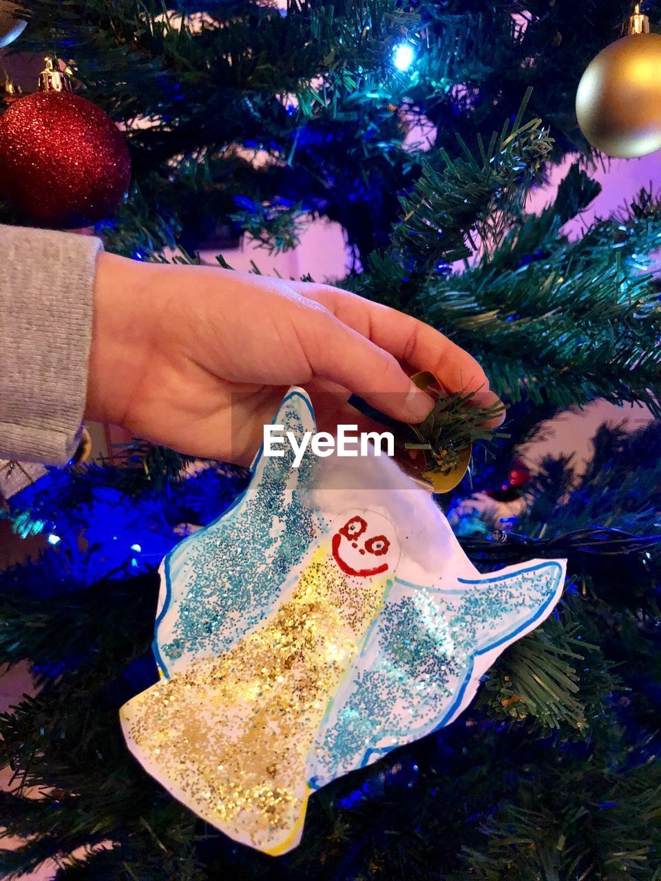 Cropped hand holding christmas decoration