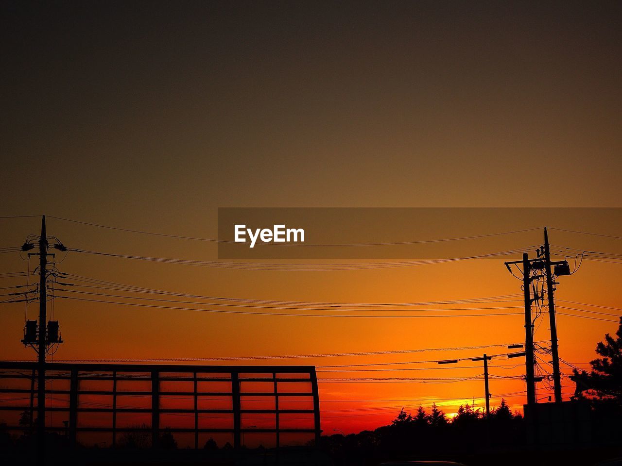 LOW ANGLE VIEW OF SILHOUETTE CRANES AGAINST DRAMATIC SKY