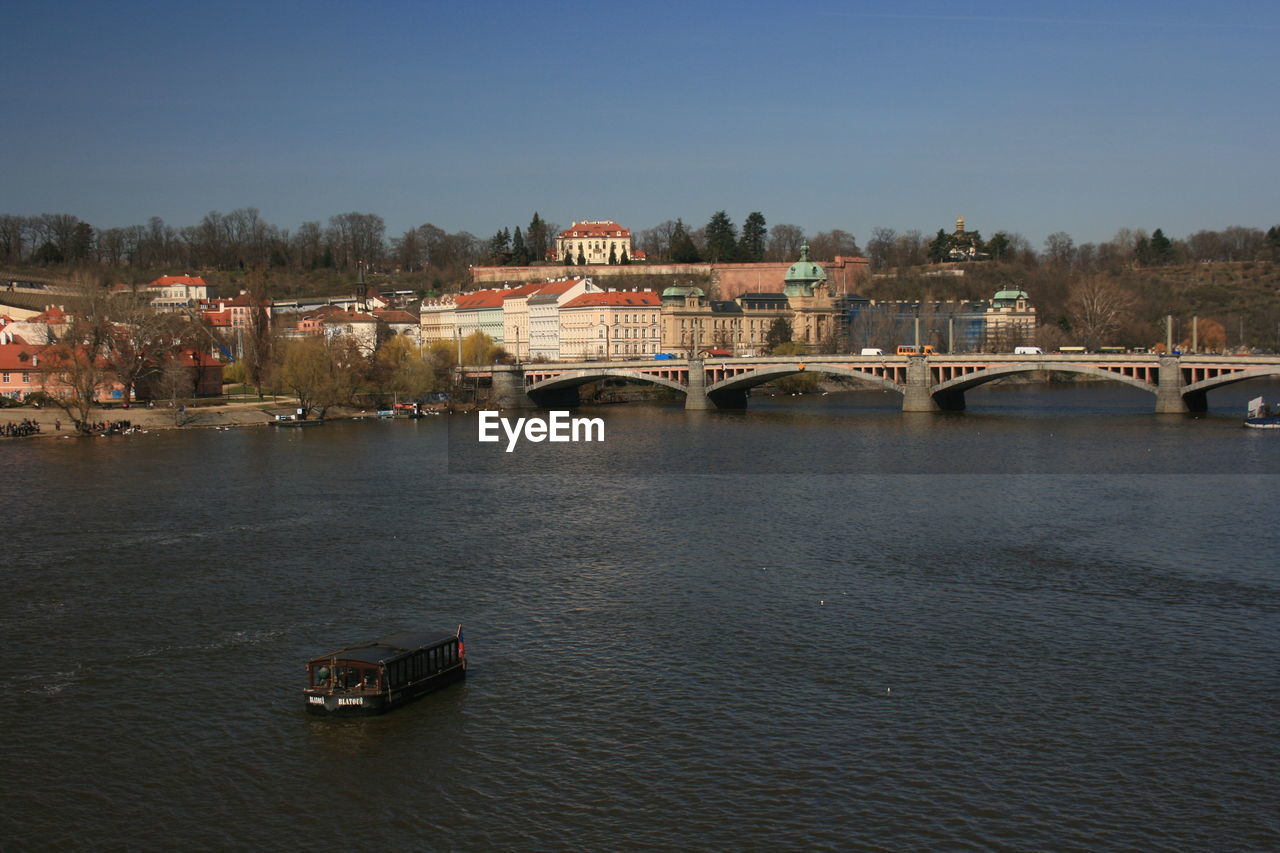 BRIDGE OVER RIVER AGAINST BUILDINGS IN CITY