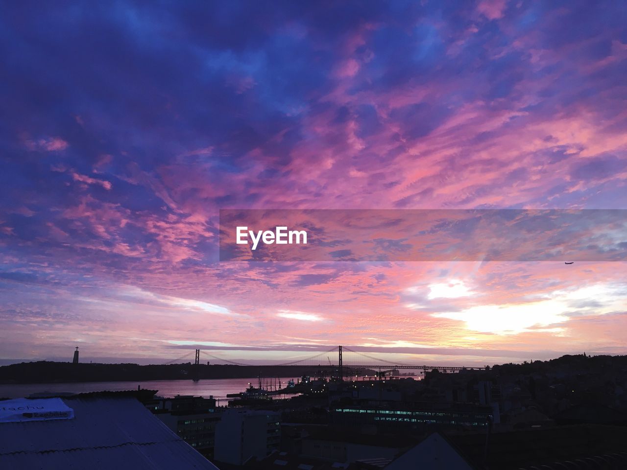 ILLUMINATED CITYSCAPE AGAINST SKY AT SUNSET