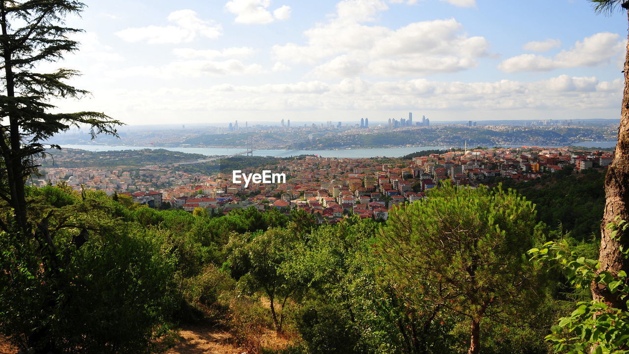 High angle view of cityscape by sea against sky