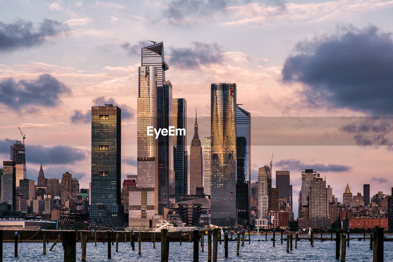 Modern buildings by sea against sky in city