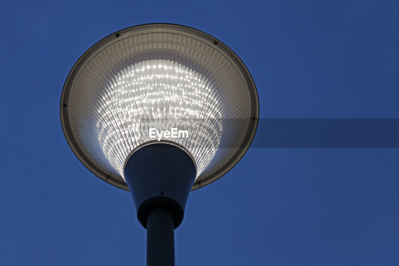 LOW ANGLE VIEW OF ILLUMINATED STREET LIGHT AGAINST SKY