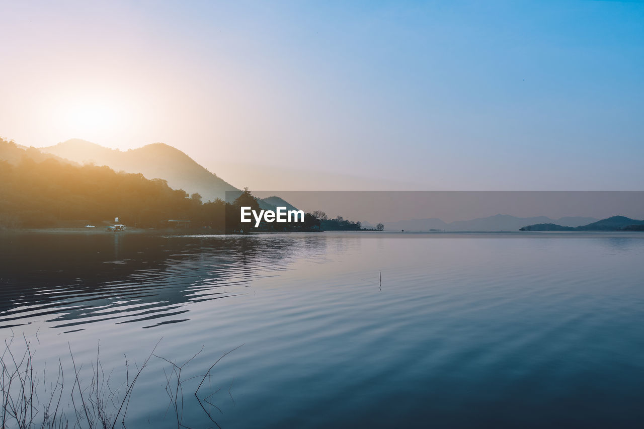 Scenic view of lake against blue sky during sunset