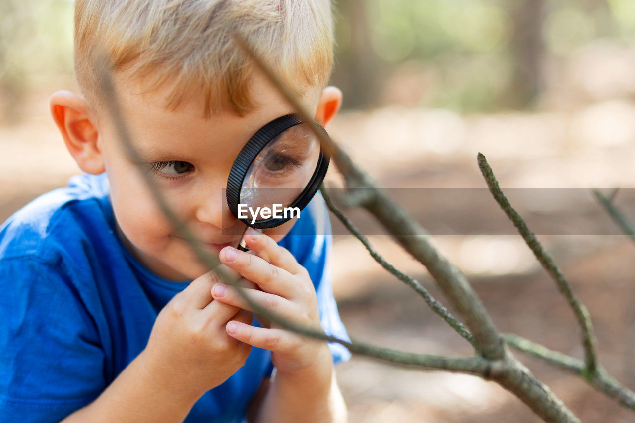 close-up of boy holding magnifying glass