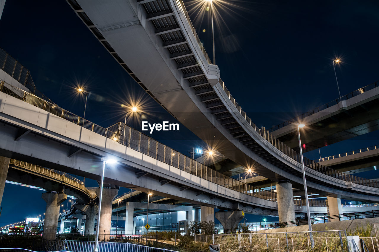 Low angle view of illuminated bridge against sky at night