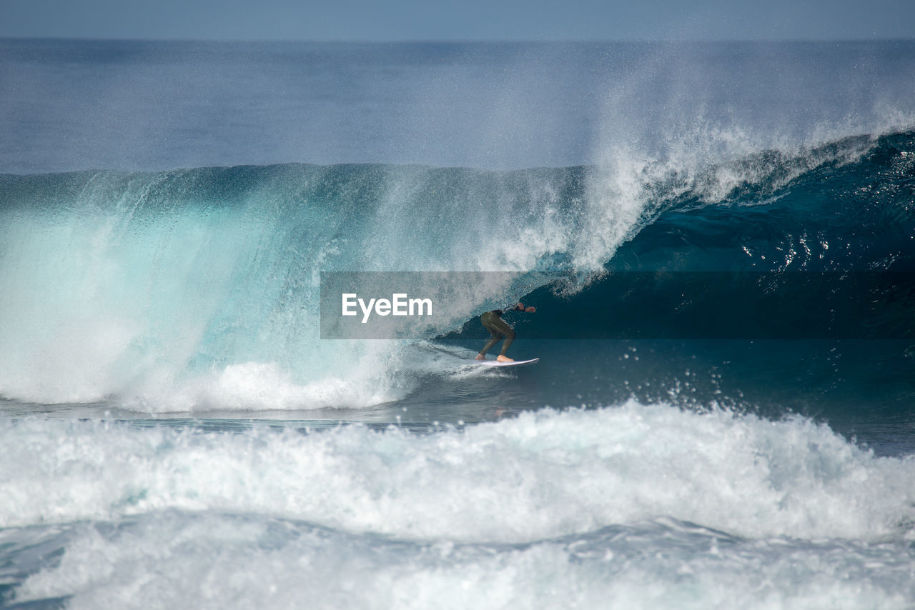 MAN SURFING ON SEA