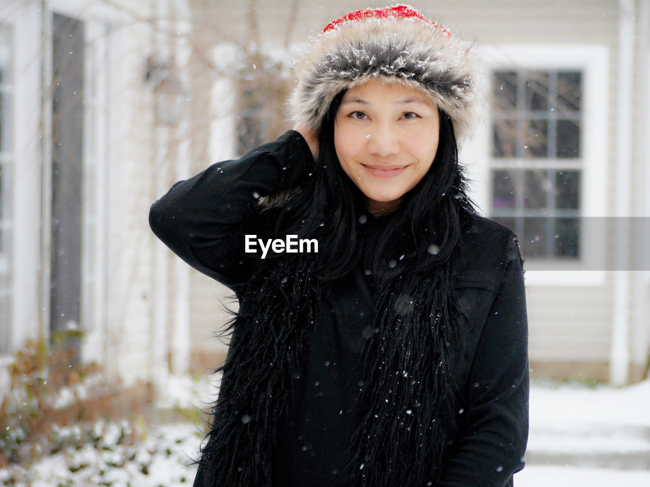 Portrait of smiling young woman during snowfall