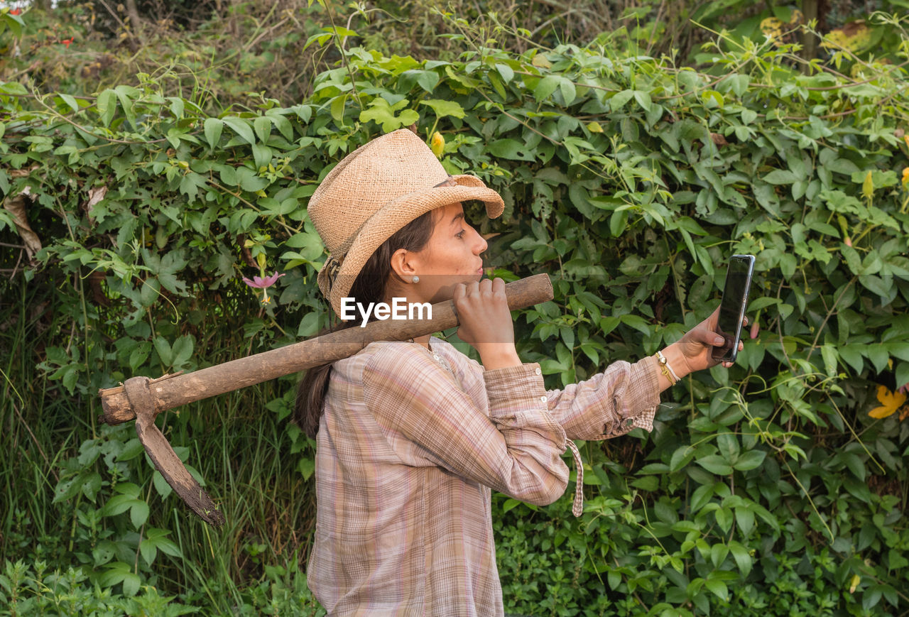 WOMAN STANDING BY PLANTS