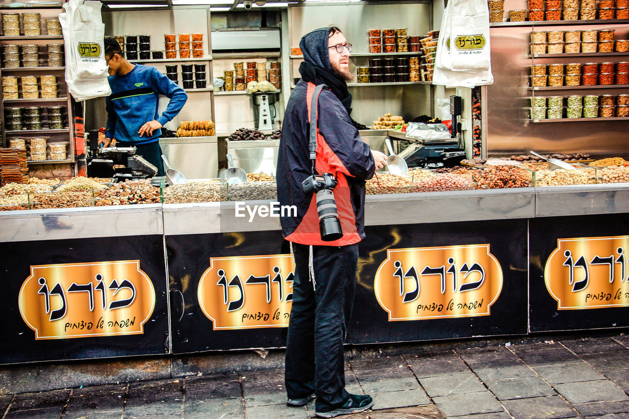 FULL LENGTH OF MAN STANDING AT MARKET STALL