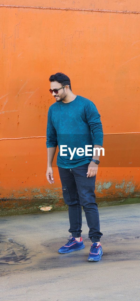 Low section of man standing on beach