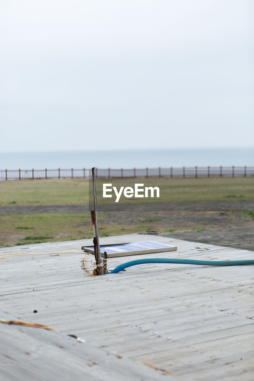  rusty iron column on the wooden floor with a sea background