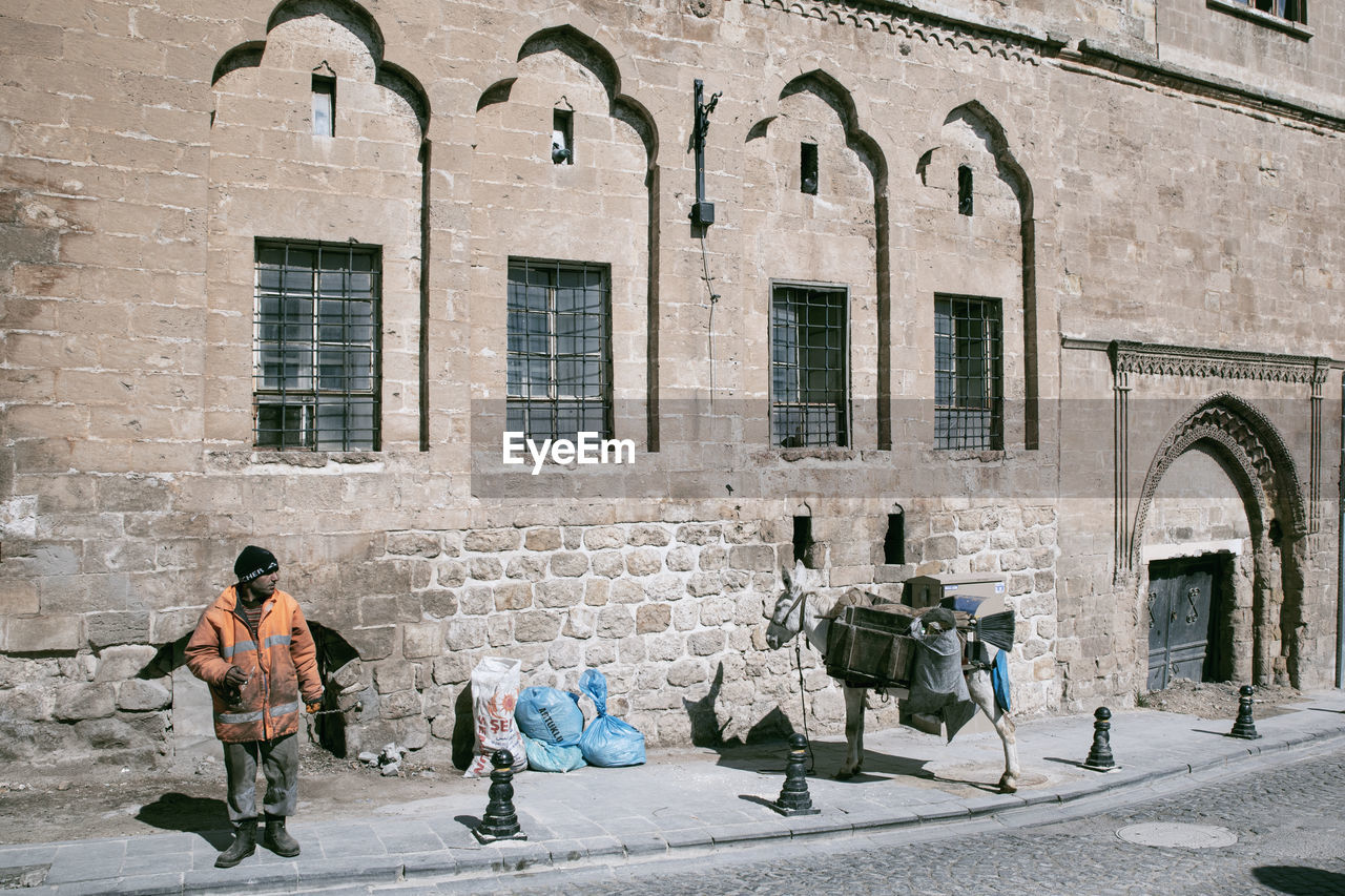 PEOPLE WALKING ON STREET BY BUILDING IN CITY