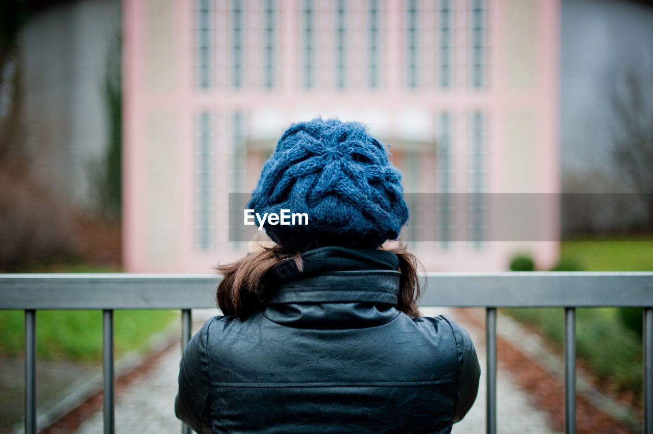 Rear view of woman standing against railing