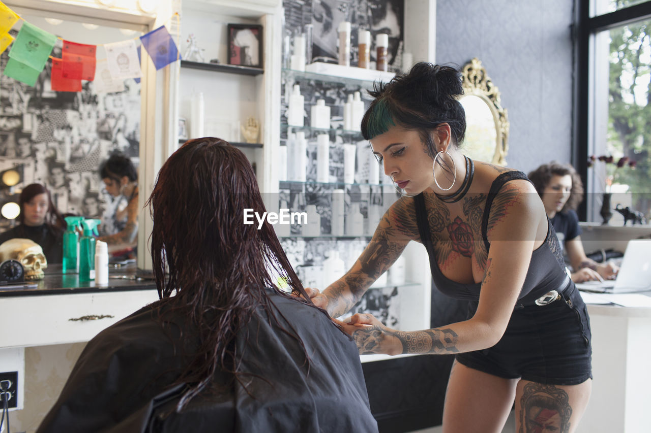 A hair dresser styling a customer's hair.