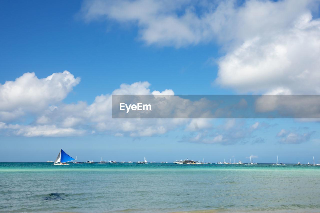 Sailboat in sea against sky