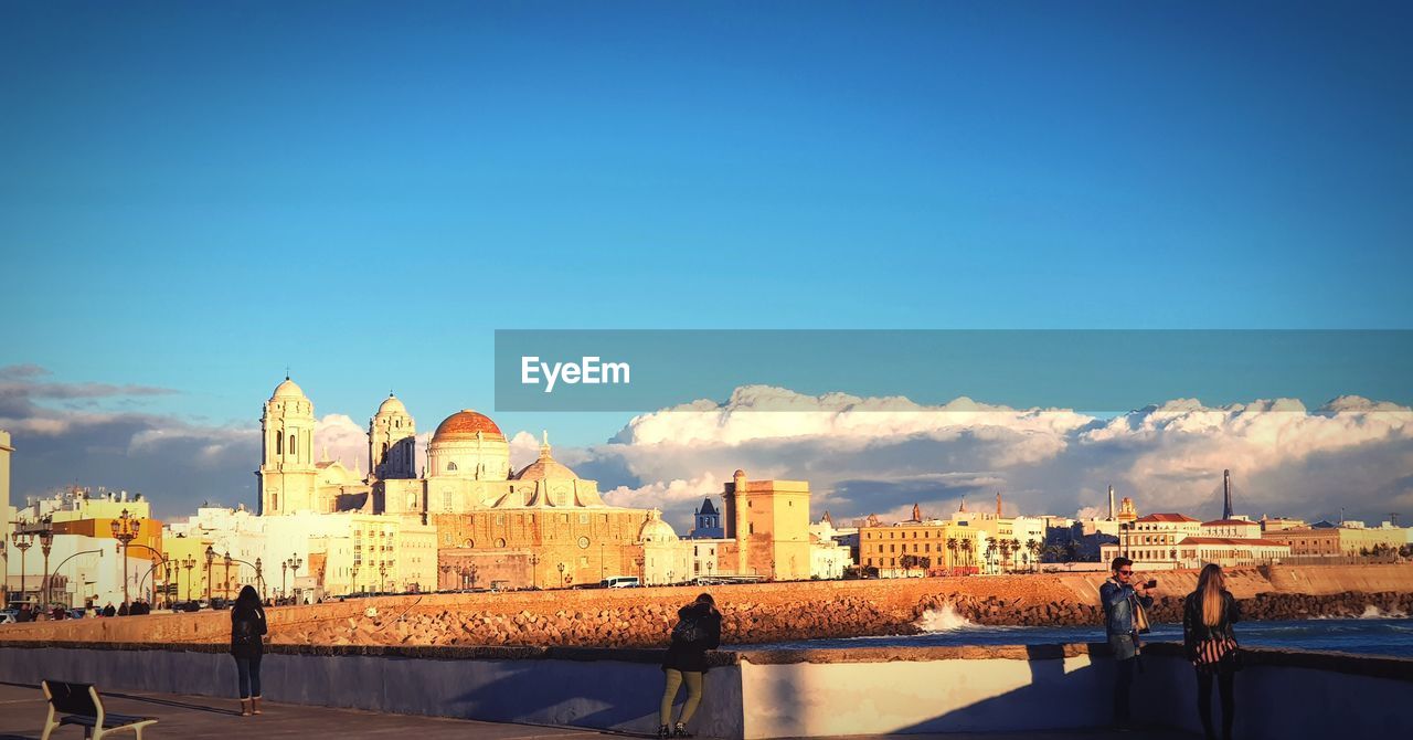 BUILDINGS AGAINST BLUE SKY WITH WATERFRONT