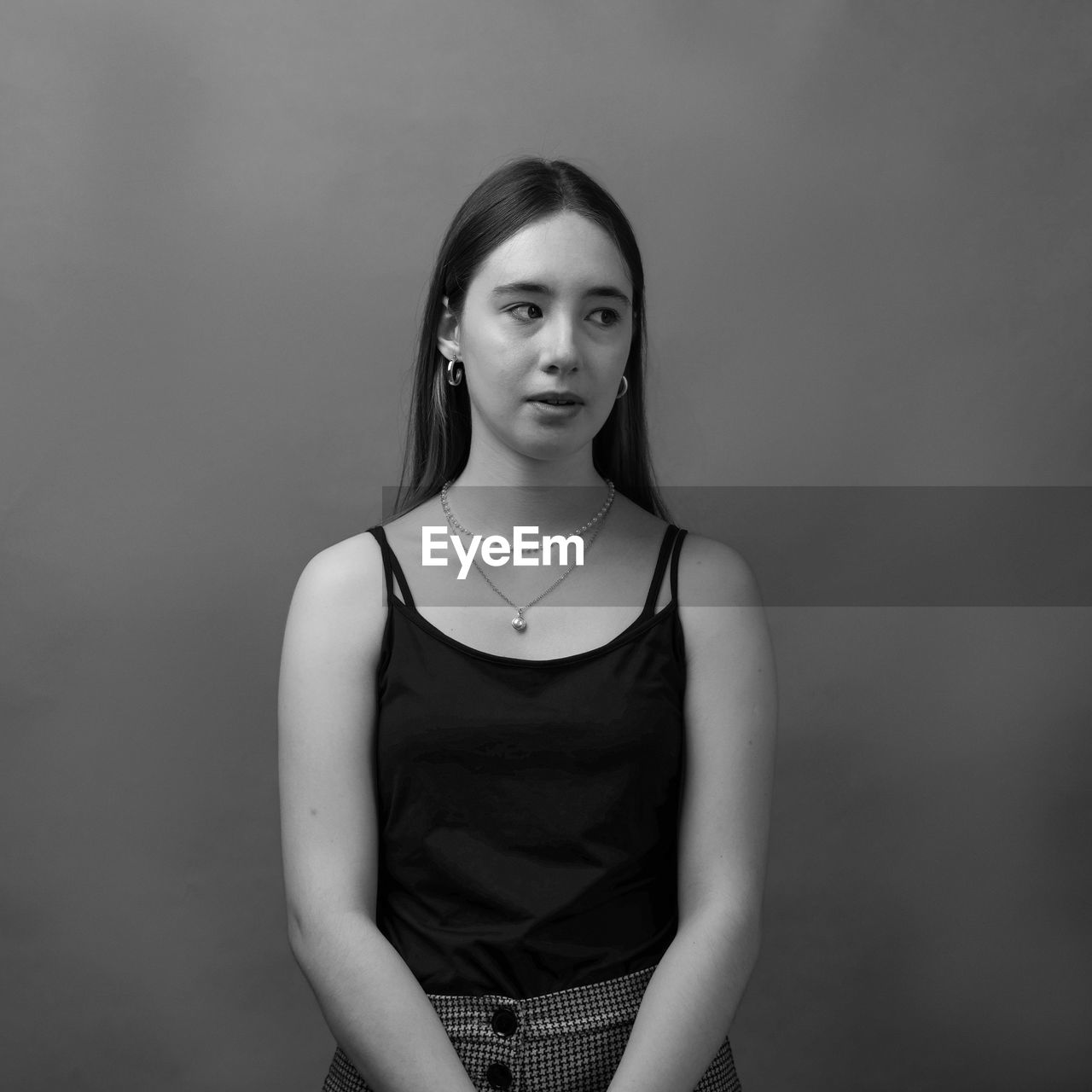 PORTRAIT OF BEAUTIFUL YOUNG WOMAN AGAINST WALL