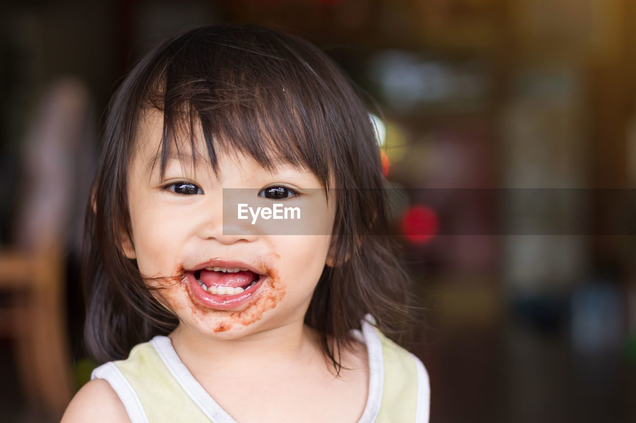 Portrait of happy cute baby girl with messy face