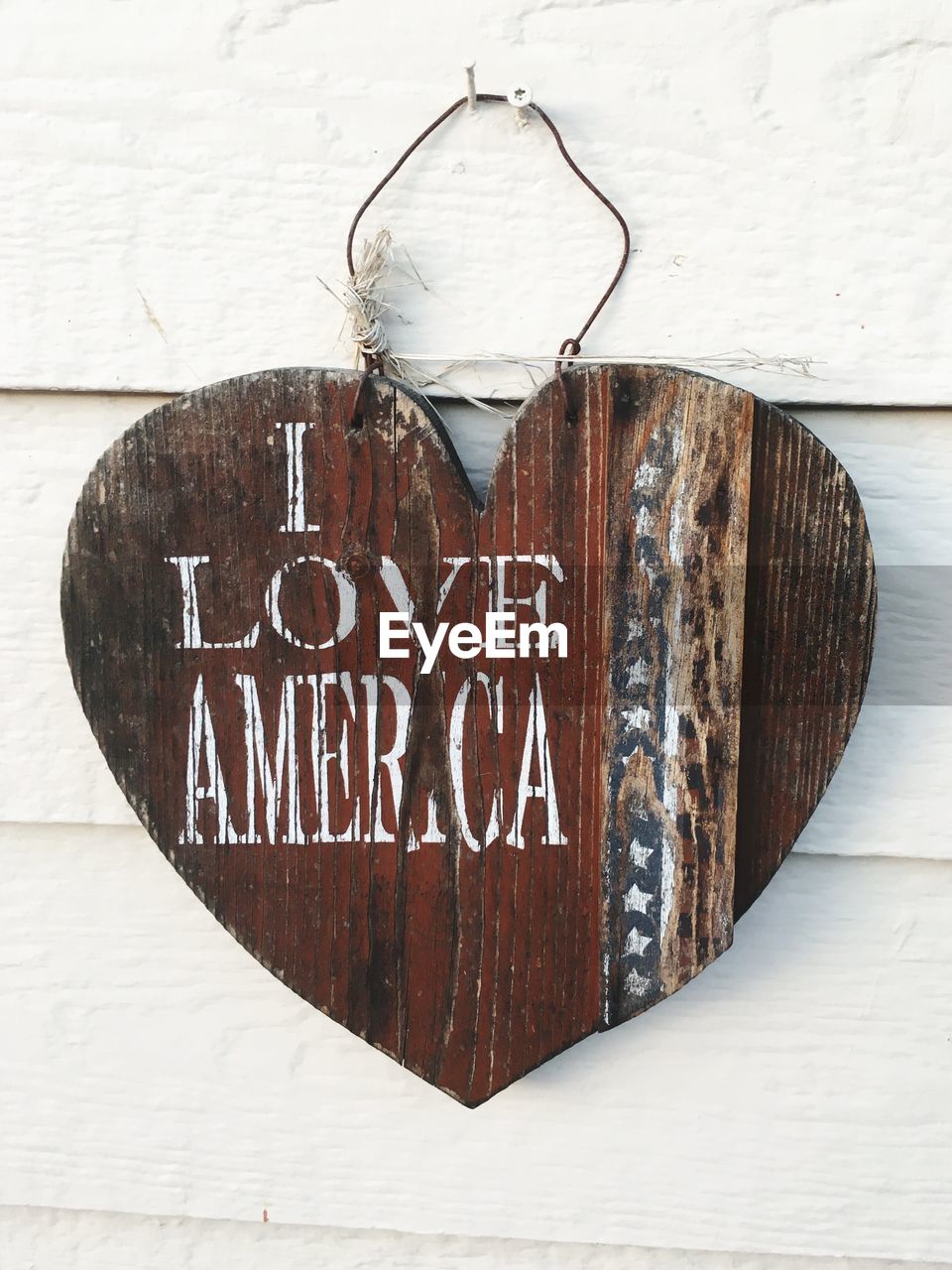 Close-up of wooden heart shape with text on wall