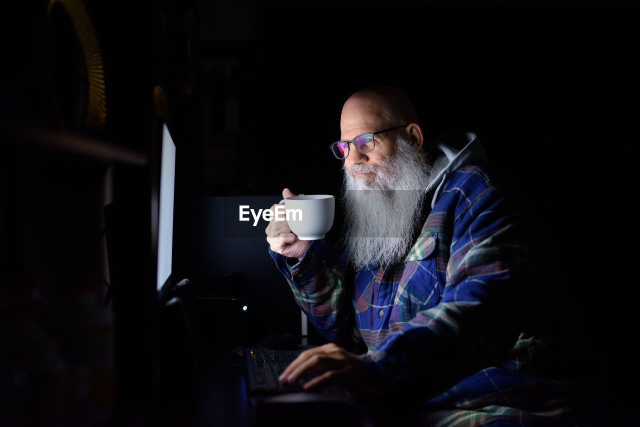 MIDSECTION OF MAN USING LAPTOP