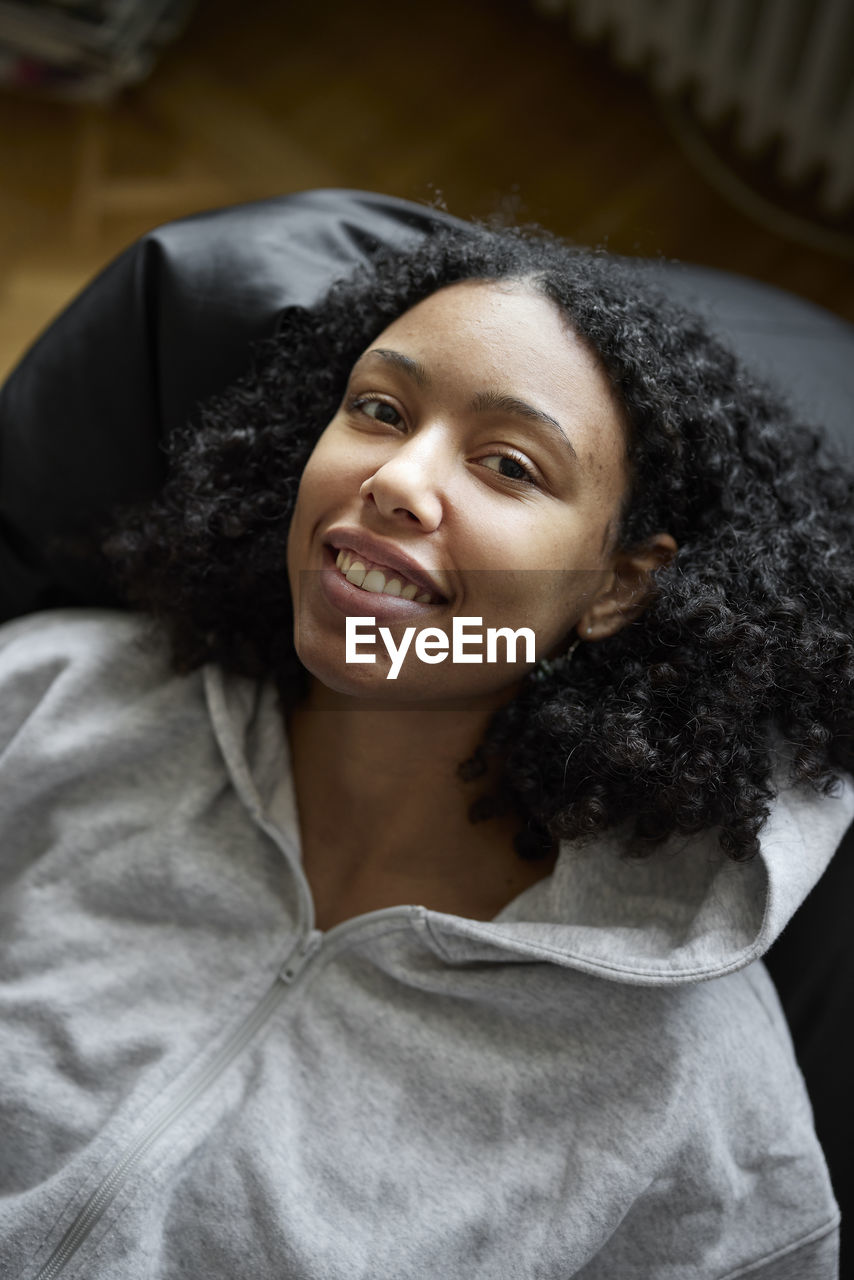 Portrait of smiling young woman lying on bean bag