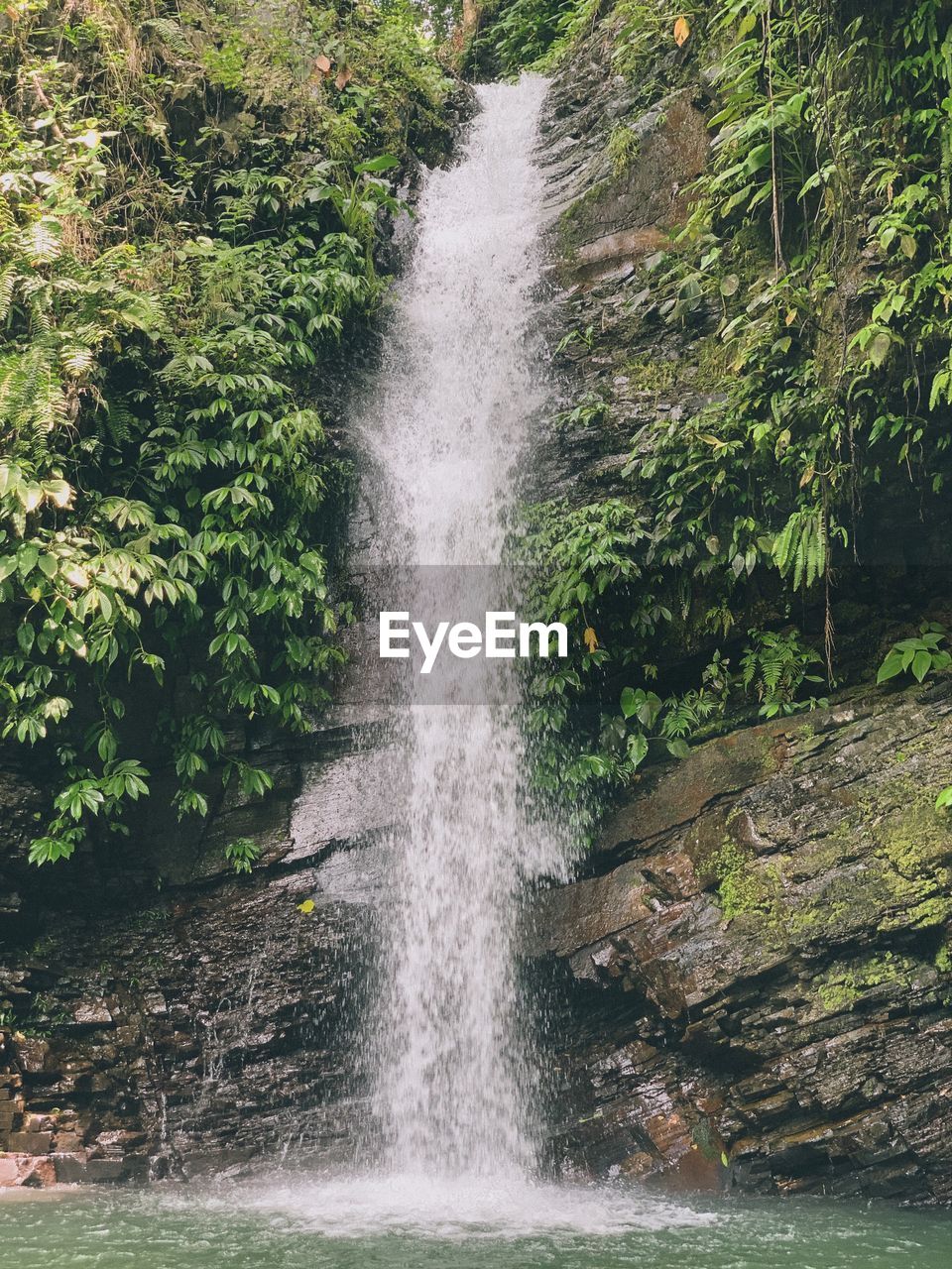 SCENIC VIEW OF WATERFALL ON SUNNY DAY