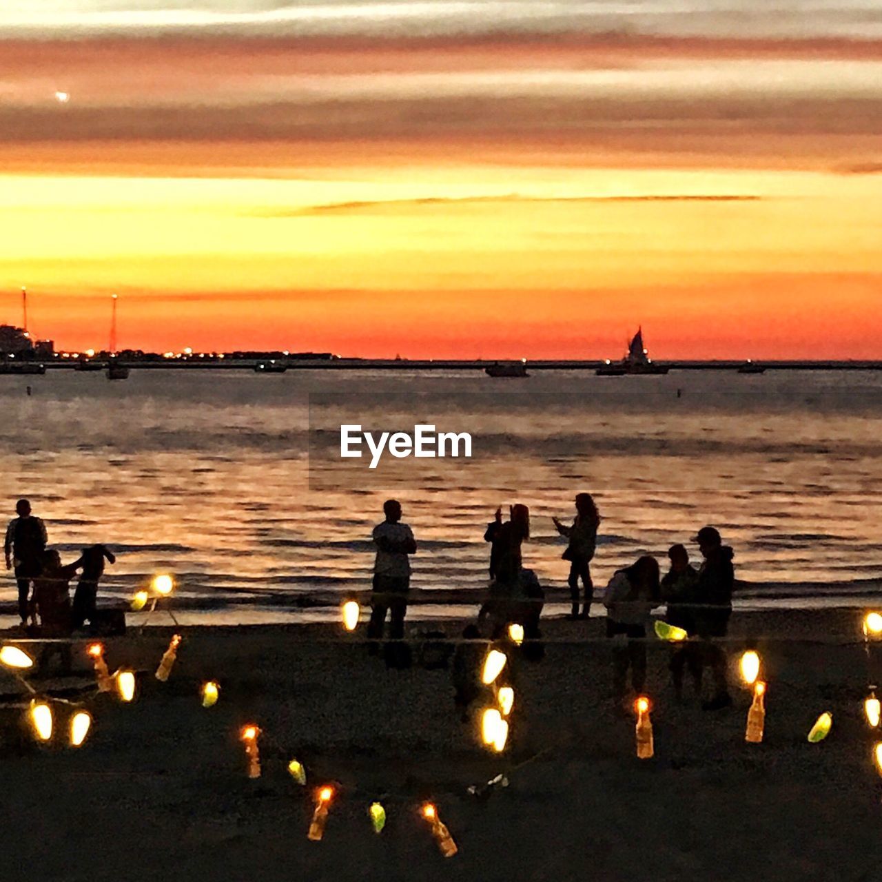 SILHOUETTE PEOPLE IN WATER AT SUNSET