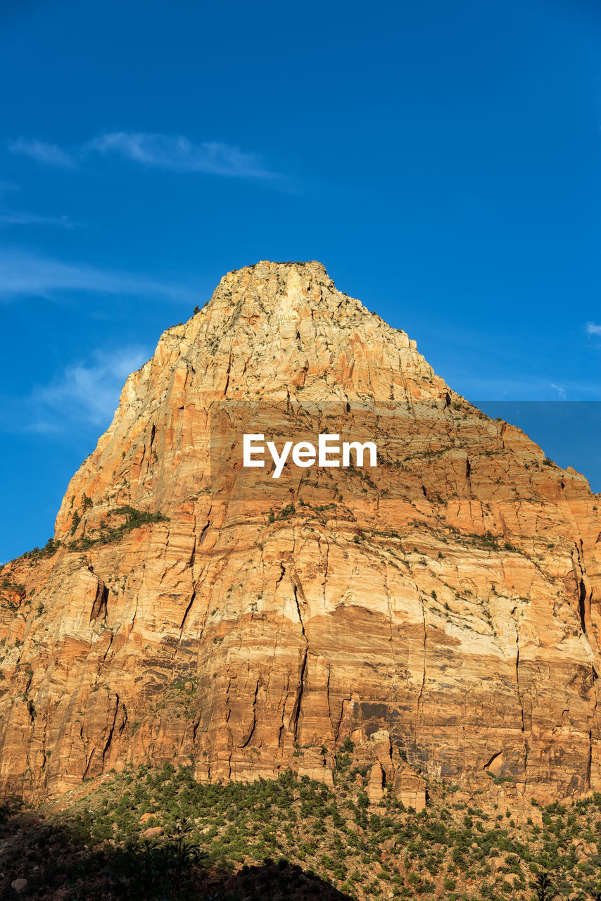 Low angle view of rocky mountain against sky