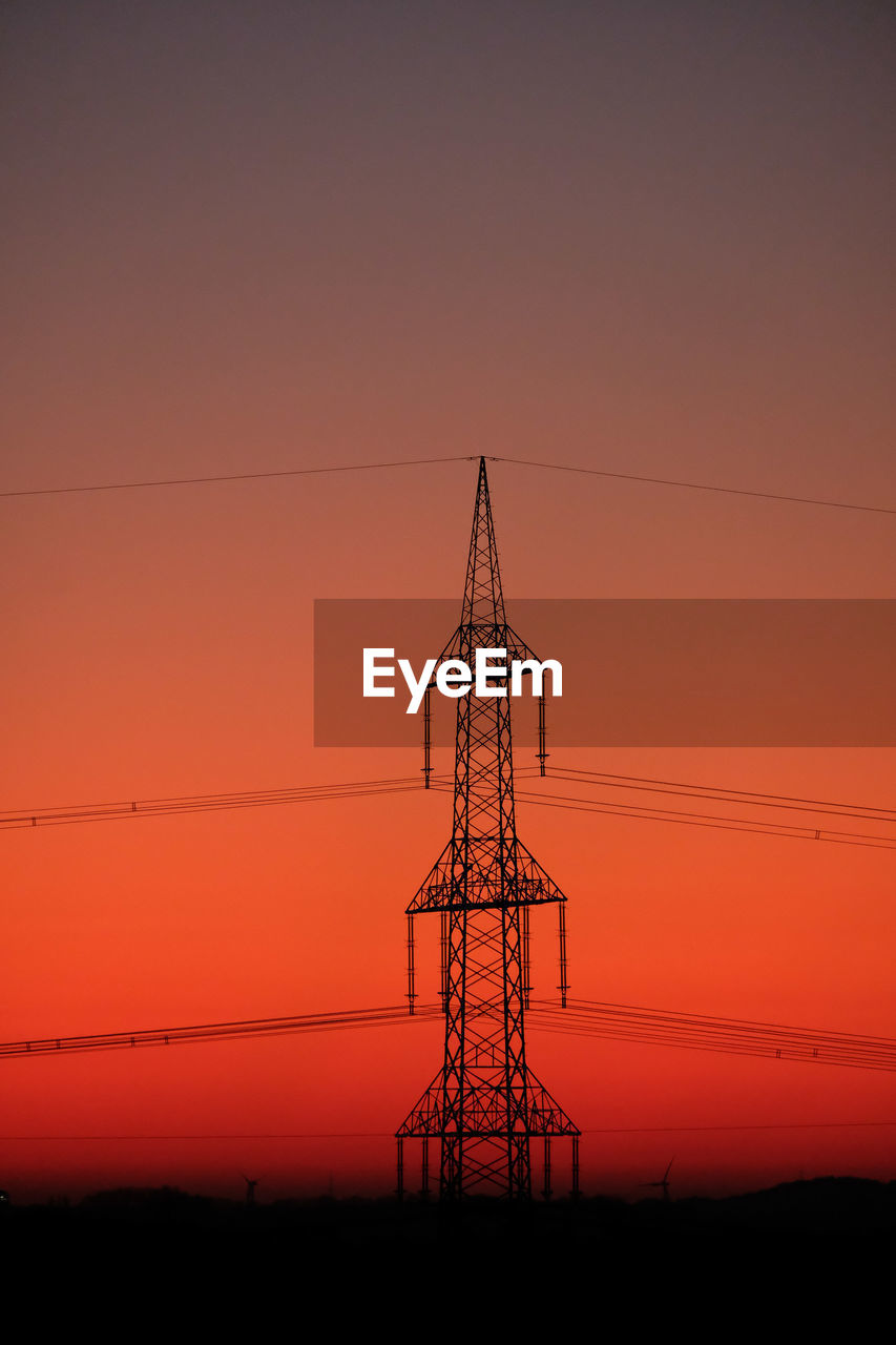 LOW ANGLE VIEW OF SILHOUETTE ELECTRICITY PYLONS AGAINST ROMANTIC SKY