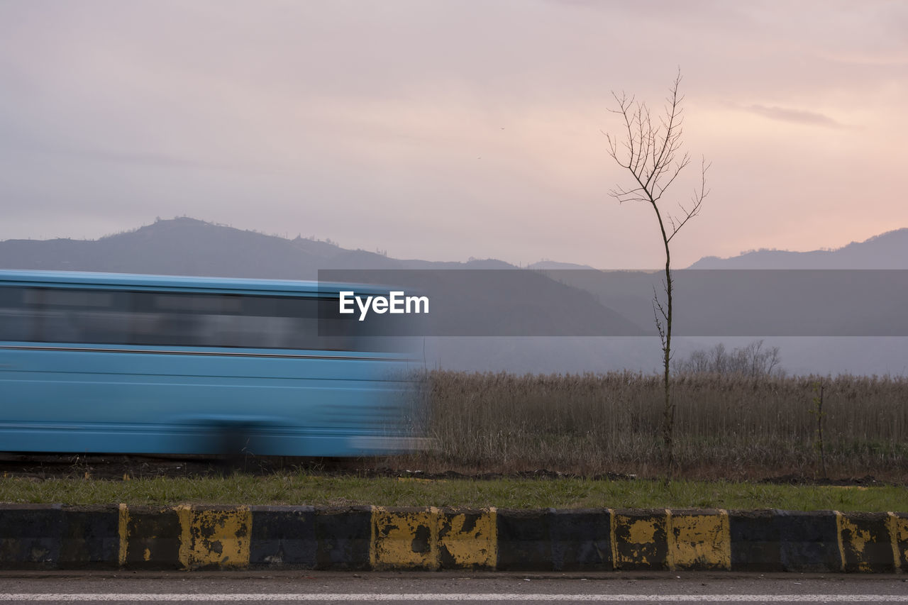 Blue mini bus vehicle moving through road. slow shutter speed photography